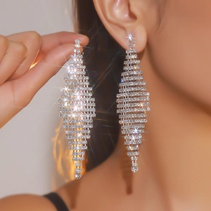 Close-up of sparkling long tassel rhinestone drop earrings with silver metal finish
