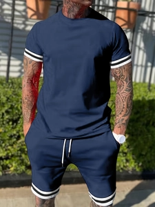 Outdoor shot of navy men's sports set with white stripe details on sleeves and shorts