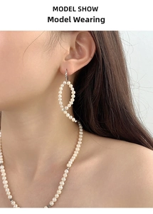 Close-up of elegant S925 silver baroque pearl earrings and necklace set on a model