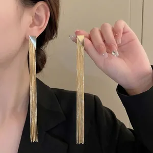 Long gold tassel earrings with geometric triangle stud and hanging metal chain fringe