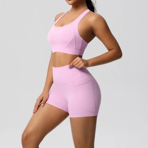 Detailed view of pink yoga bra and high-waisted shorts with side pockets on model