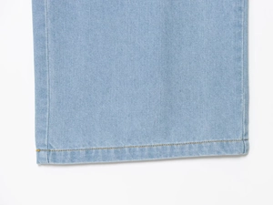 Detailaufnahme des verstärkten Saums mit Doppelnaht auf hellblauem Denim-Stoffmaterial