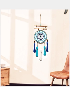 Detail of blue and white cotton woven dreamcatcher with hanging tassels and wood beads