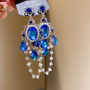 Detailed close-up of vintage baroque earrings with royal blue stones and beaded tassels