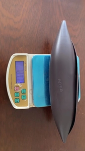 Brown silicone cooking bowl on scale showing product weight of 184.1 grams
