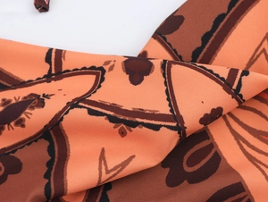 Close-up of lightweight chiffon fabric with vintage orange and brown geometric patterns