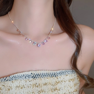 Detail of pink crystal pendant necklace featuring sparkling round gemstones on a silver chain