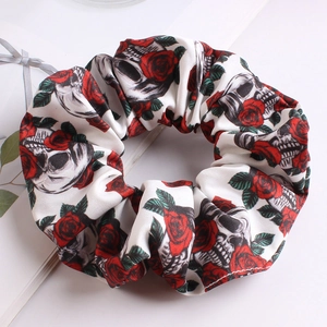 Detail of white scrunchie featuring vintage skull and red rose floral pattern prints