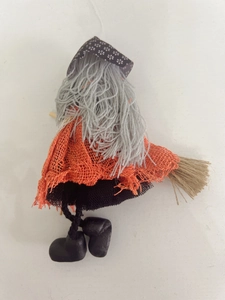 Rear view of Halloween witch doll with orange burlap cape and black mesh skirt