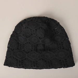 Detail of the intricate crochet floral lace pattern on this black summer beanie hat