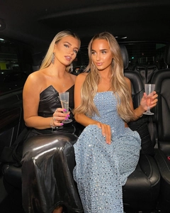 Détail d'un haut bleu à paillettes et d'une robe corset en cuir noir dans une voiture