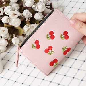 Close-up of pink cherry embroidery wallet with pebbled leather texture and zipper detail