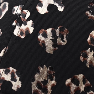 Detail of black twill fabric featuring leopard head print for criss cross ponytail caps