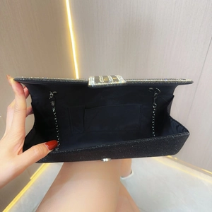 Macro detail of black glitter evening clutch showing interior lining and chain strap