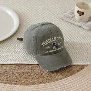 Detailed view of grey washed cotton baseball cap with vintage white embroidery and torn brim