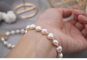 Close-up of elegant freshwater pearl bracelet with gold beads worn on a model wrist