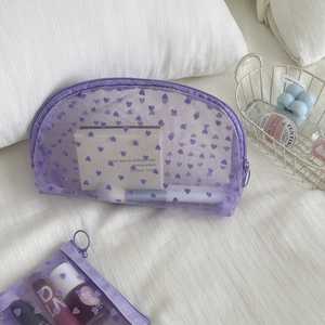 Detail of purple mesh makeup bag with velvet hearts showing zipper and transparency