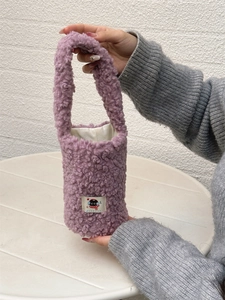 Detail of soft purple plush cup sleeve with cute black cat patch and fuzzy texture