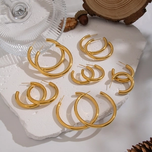 Minimalist 18K gold plated stainless steel C-shaped hoop earrings on marble
