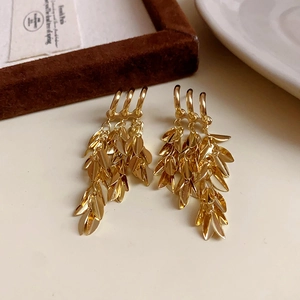 Detail of vintage gold leaf tassel earrings with multi-layer dangling foliage design