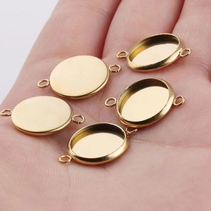 Golden stainless steel oval pendant base trays for DIY jewelry making held in hand