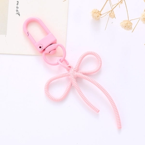 Gros plan d'un porte-clés en métal rose en forme de nœud avec fermoir mousqueton robuste