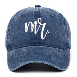 Detail of navy blue washed denim baseball cap with white cursive Mr. embroidery