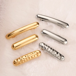 Detailed close-up of metallic gold and silver hair ties with unique hammered textures