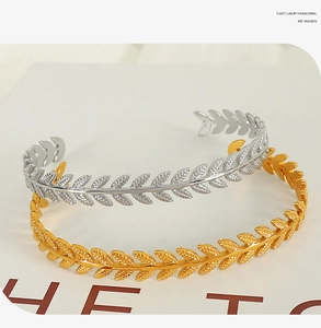 Detailed view of layered C-shaped cuff bangles with delicate olive leaf engravings