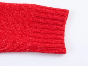 Detailed macro shot of the ribbed cuff texture on a red chunky knit sweater sleeve