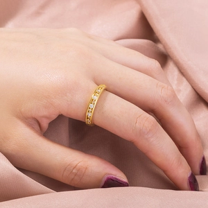 Close-up of elegant gold ring with a row of sparkling cubic zirconia on pink silk