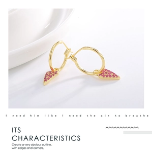 Detail of gold-plated hoop earrings with sparkling red triangular zircon stones