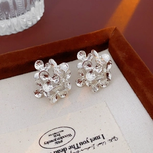 Close-up of silver-toned flower cluster earrings with intricate petal details