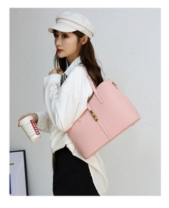 Grand sac cabas en cuir tressé rose avec fermoir rotatif en métal porté par un mannequin