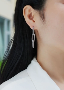 Detail view of 925 silver dangling chain earrings with pave-set shimmering moissanite