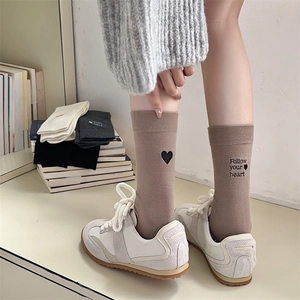 Detail of brown cotton mid-tube socks with black heart and Follow your heart embroidery