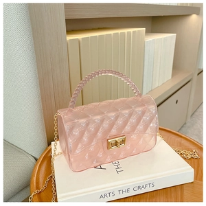 Close-up of pink jelly bag with quilted texture, beaded handle, and gold chain strap