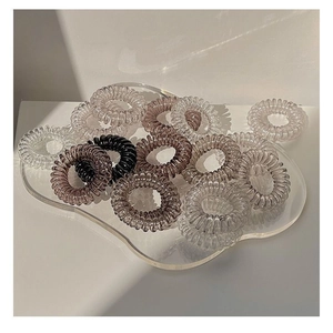 Macro shot of assorted spiral telephone wire hair ties on a clear acrylic board