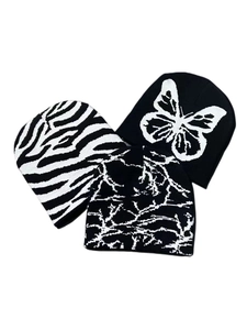 Detailed flat lay of three Y2K knit beanies featuring butterfly and zebra patterns