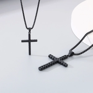 Gros plan du pendentif croix en acier inoxydable noir avec détails de texture tressée