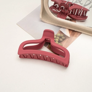 Close-up of a matte dark red shark hair claw clip showing its smooth texture and grip