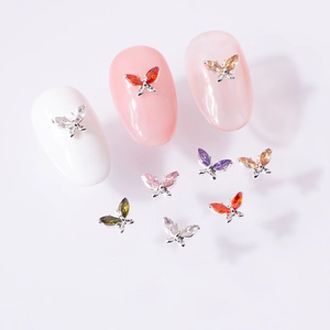 Macro shot of 3D zircon butterfly nail art charms on manicure tips with silver alloy base