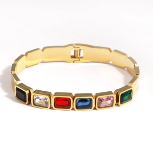 Détail d'un bracelet doré en acier titane orné de pierres précieuses multicolores