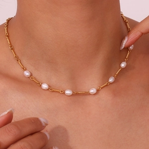 Detail of 18K gold-plated twisted chain necklace with delicate freshwater pearls