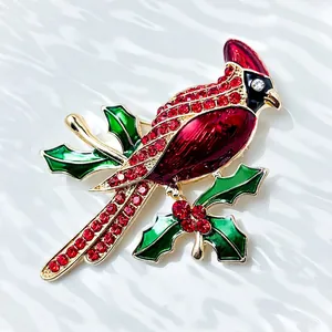 Detailed cardinal bird brooch with red rhinestones and green enamel leaves on gold branch
