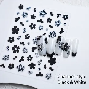 Detailed view of floral nail art stickers with black and white flowers and bowknot designs