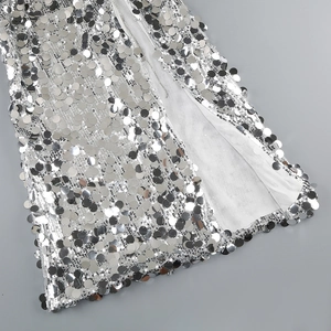 Macro shot of silver sequin dress detailing with large round sequins and fine stitching