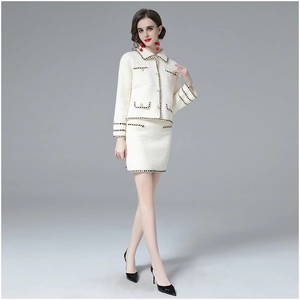 Close-up of pearl buttons and black braided trim on tweed jacket and skirt set