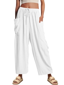 Detail view of white wide-leg trousers featuring an elastic drawstring waist and side pockets