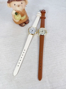 Detailed view of elegant quartz watches with Roman numeral dials and leather straps